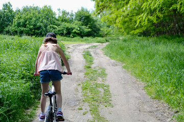 Young girl cyclist enjoy the beautiful sunrise on summer forest trail