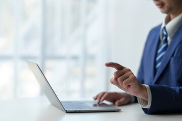 businessman working on laptop computer Print email check work Send information online on white desk Finger pointing at business goals planning success in office.