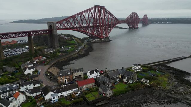 The Forth rail bridge is a cantilever railway bridge across the Firth of Forth. Cinematic aerial drone shot of Forth Rail Bridge, Scotland, Forth Road bridges in background, rainy day.