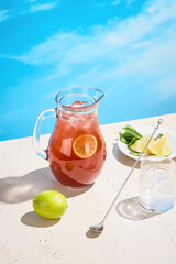 Strawberry and lime lemonade in a pitcher, ready to serve on a warm, sunny day