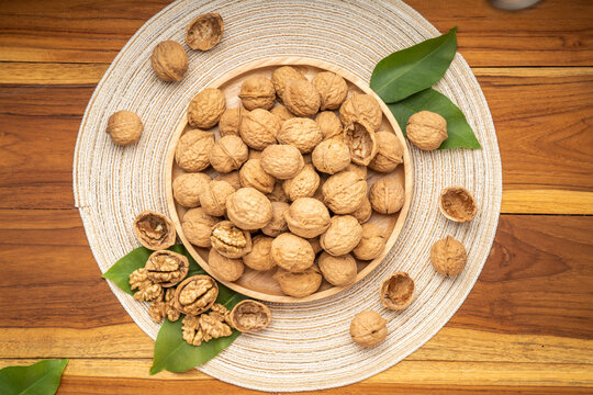 Walnuts in wooden tral on wooden background, Walnuts kernels on wooden table.