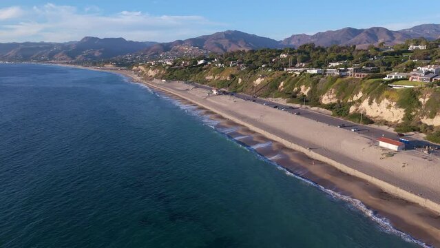 Tracking shot of beaches along the coast of Malibu, California.