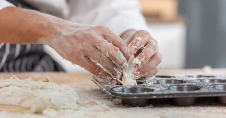 professional Chef sifting flour powder and sprinkling ingredients on massaging dough for bakery cooking. Chef show dirty finger hand sifting flour wheat and kneading dough mixing powder.