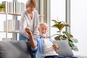 Senior couple in living room, Elderly man suffers from numbing pain in hand, senior man having...