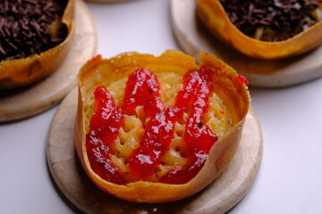 Martabak Manis. Sweet martabak. Sweet snack made from flour, eggs, vanilla, topped with grated cheese, chocolate meses, jam and pineapple, strawberry jam. Served on marble table. Indonesian food.
