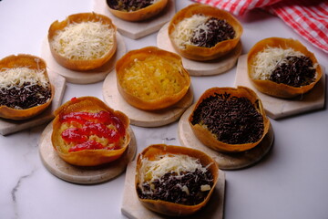 Martabak Manis. Sweet martabak. Sweet snack made from flour, eggs, vanilla, topped with grated cheese, chocolate meses, jam and pineapple, strawberry jam. Served on a white marble. Indonesian food.