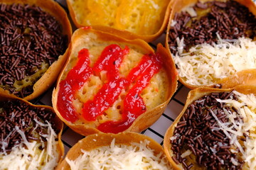 Martabak Manis. Sweet martabak. Sweet snack made from flour, eggs, vanilla, topped with grated cheese, chocolate meses, jam and pineapple, strawberry jam. Served on a cooling rack. Indonesian food