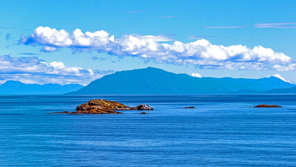 Rocky Island on the background of mountain range in the Strait of Georgia British Columbia