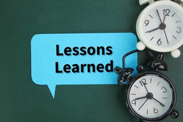 alarm clock and chat box with the words Lessons learned. the concept of learning or Coaching