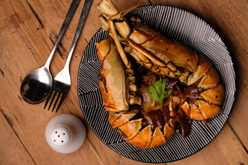 Lobster saus lada hitam or Lobster in black pepper sauce. Served on a ceramic plate. Stainless...