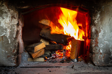 A stack of wooden planks is burning in the old hearth