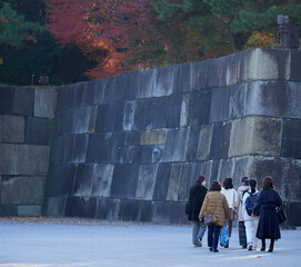 秋の江戸城で歩く女性たちの観光客の姿