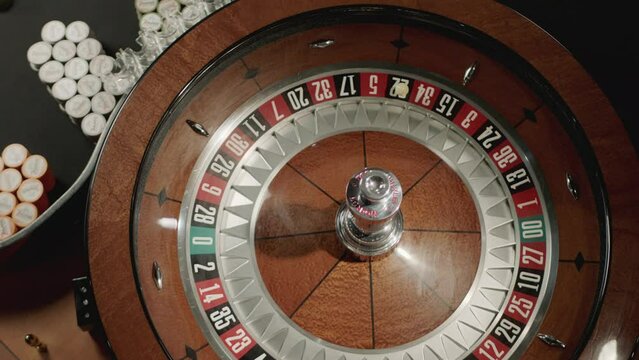 Top view slow motion of the white ball drops to number 3-red while the roulette wheel spinning