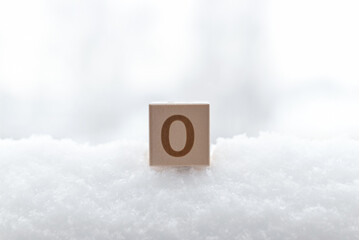 Temperature, weather in winter. Close-up of a wooden cube with the number 0 degrees Fahrenheit in the snow during the day.