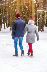 Fototapeta na wymiar A guy and a girl walking in winter Park 