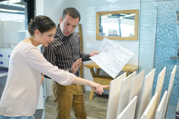 couple pointing at ceramic tile for bathroom floor in store