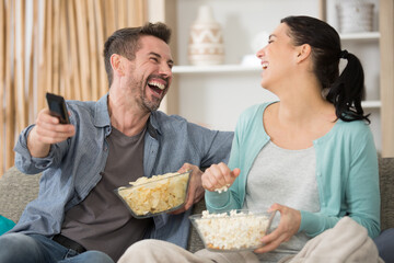 couple with popcorn watching tv together