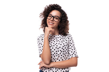 young authentic curly brunette slim lady wearing polka dot short sleeve shirt on white background