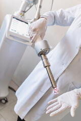 female doctor holds in hands carbon dioxide laser with phallic attachment for vaginal rejuvenation. Hardware cosmetology and medicine. Skin tightening, scar removal, stretch marks and lifting closeup