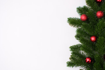 Fototapeta na wymiar Fir branches with red christmas balls on white background. Top view.