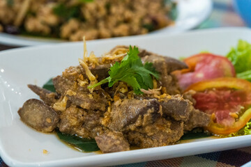 Fried liver with garlic on a white dish