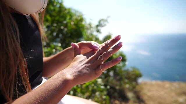 Woman with many boho rings on fingers near sea. Happy tourist enjoy taking picture outdoors for memories. Close up. Slow motion