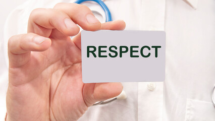 respect word on the card in a man's hand on the background of a white shirt