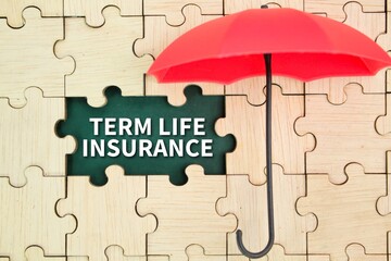 red umbrella and wooden puzzle with the word term life insurance. insurance coverage concept