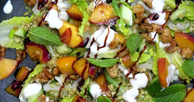Grain salad with nectarine rotating on plate. Healthy plant based vegan food. High resolution 4k cooking footage.