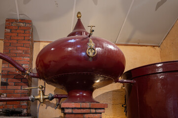 Double distillation process of cognac spirit in Charentias copper still pots and boilers in...