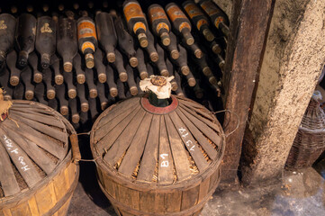 Aging process of cognac spirit in old French oak barrels in cellar in distillery in Cognac white...