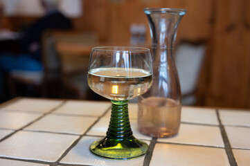 White quality riesling wine served in green swirl wine glass in old German restaurant in Monschau...