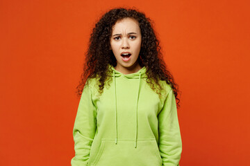 Young sad shocked scared indignant woman of African American ethnicity she wearing green hoody...