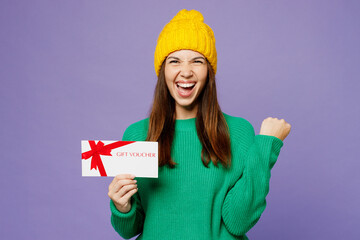 Young woman she wearing green sweater yellow hat casual clothes hold gift certificate coupon...