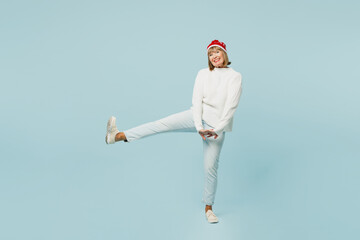 Full body merry rejoicing smiling elderly woman 50s years old wear sweater red hat posing look...