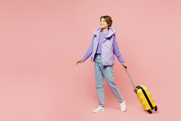 Sideways traveler woman wears vest casual clothes hold bag stroll go isolated on plain pastel pink background. Tourist travel abroad in free spare time rest getaway. Air flight trip journey concept. - Powered by Adobe