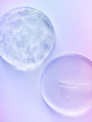 glass pipette serum gel closeup in petri dish on a light multicolored background