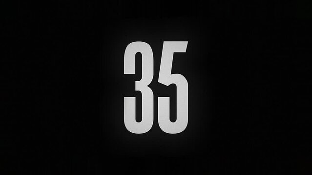 The number 35 smolders and burns on a black background, the number is on fire