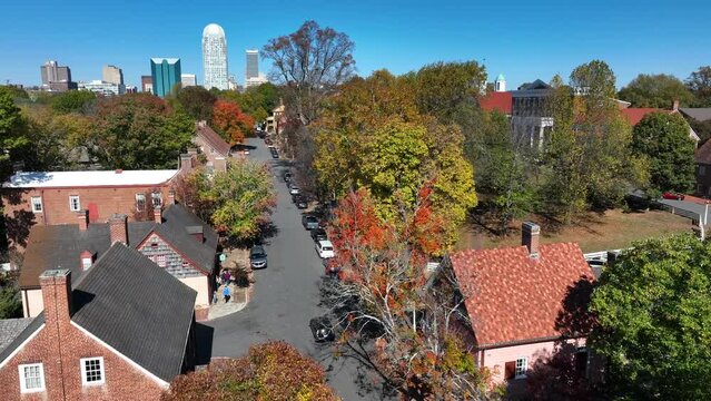 Old Salem in autumn. Aerial shot with Winston-Salem, North Carolina skyline in background.