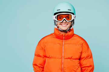 Young smiling happy skier woman she wear warm padded windbreaker jacket hat ski goggles mask helmet...