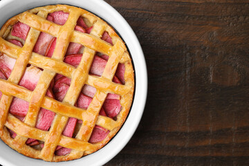 Baking dish with tasty apple pie on wooden table, top view. Space for text