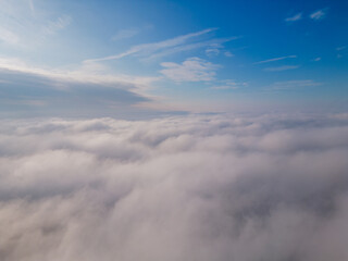 A drone flies over fluffy clouds. The drone flies through the clouds, creating a sense of wonder and awe