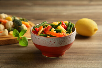 Frozen vegetables in bowl on wooden table