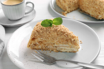 Piece of delicious Napoleon cake served on table, closeup