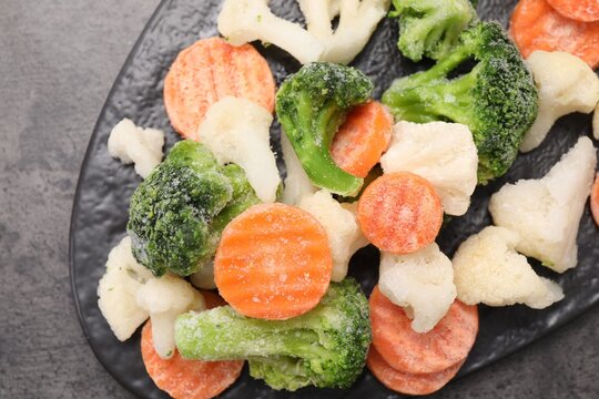 Mix of different frozen vegetables on grey table, top view