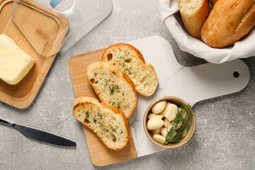 Tasty baguette with garlic and dill served on light grey table, flat lay