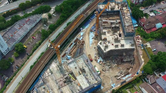 Aerial shot drone flyover residential building construction site located next to KTM railway at Seputeh, Kuala Lumpur, Malaysia, slowly revealing the complex interchange of nearby highways.