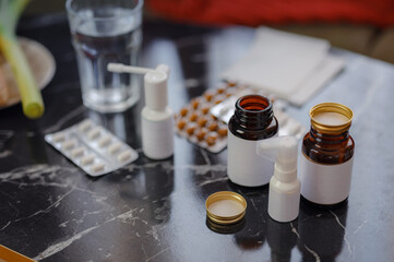 A handful of pills scattered on the table. A vial of medicines. Marble surface. Nobody in space with medical treatment, tablets of capsules, bottles of pills for ill person