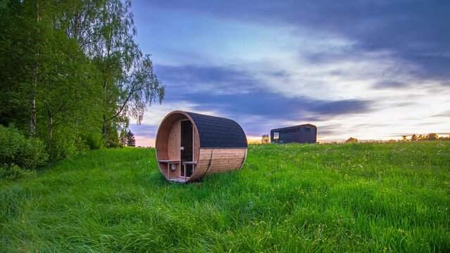 A trailer or tiny house and sauna in a countryside meadow as the seasons transition - summer, autumn, winter time lapse