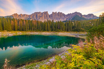 Lago di Carezza, where emerald waters meet misty forests and Latemar views, crafting an enchanting Alpine canvas.